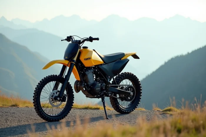 Fantic Enduro 50 en jaune et noir sur colline de gravier avec vallée alpine en arrière-plan